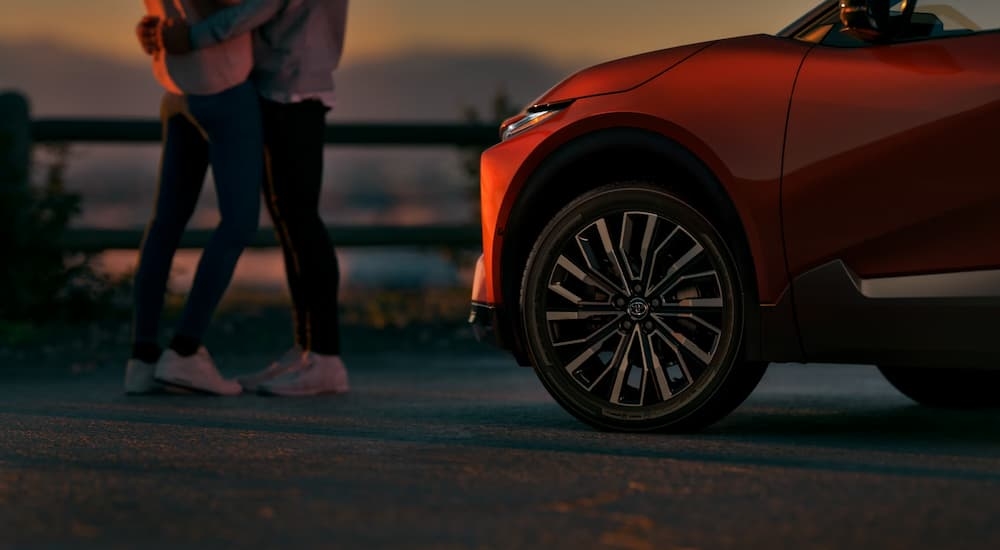 Couple standing near an orange 2026 Toyota CH-R