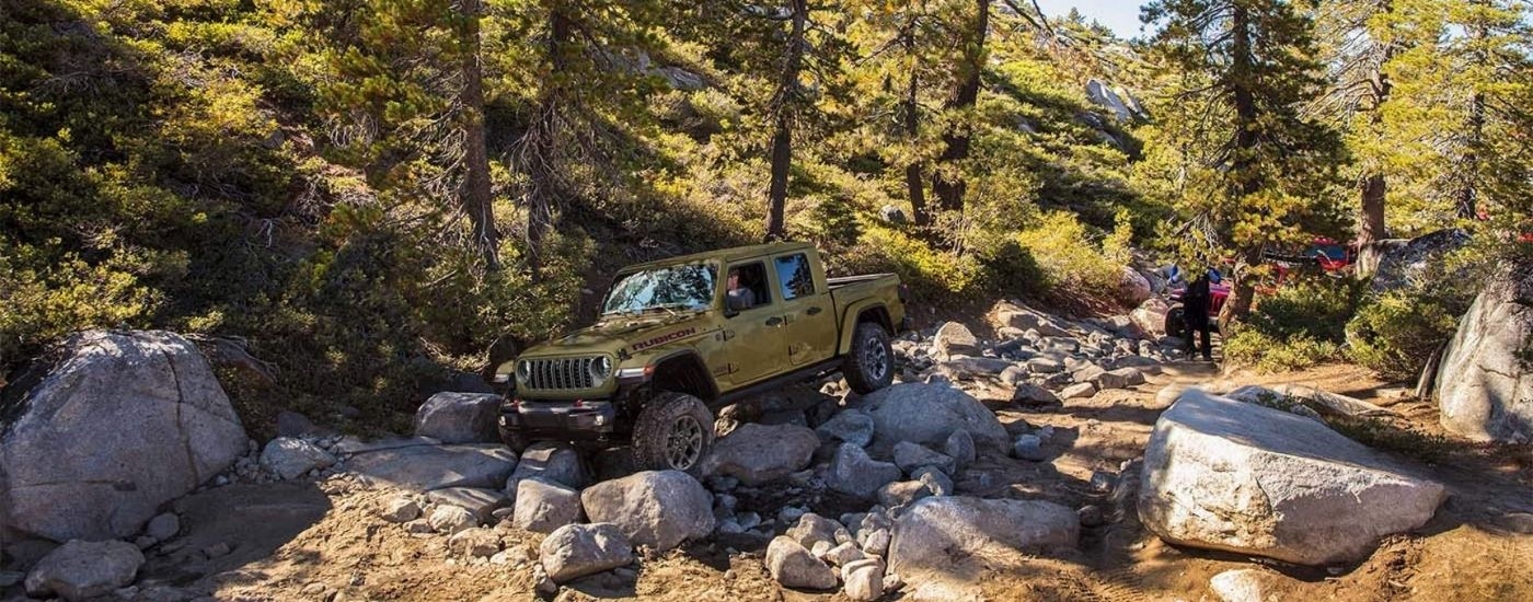 A green 2025 Jeep Gladiator from the side.