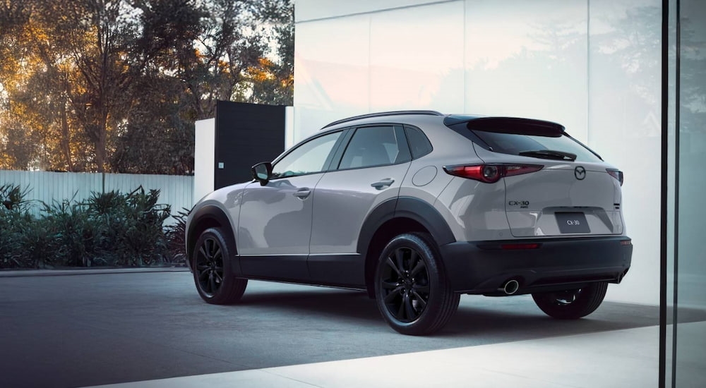 Rear of a grey 2026 Mazda CX-30 parked outside a building.