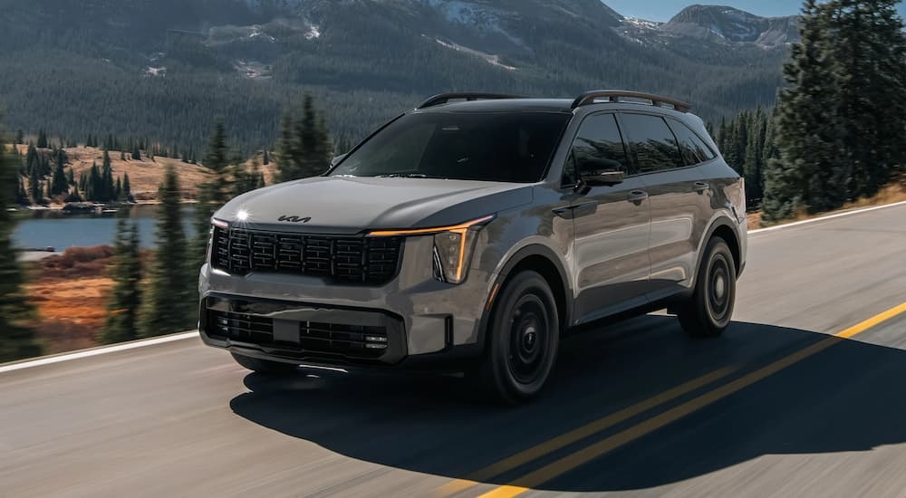 Grey 2026 Kia Sorento driving on a mountain road