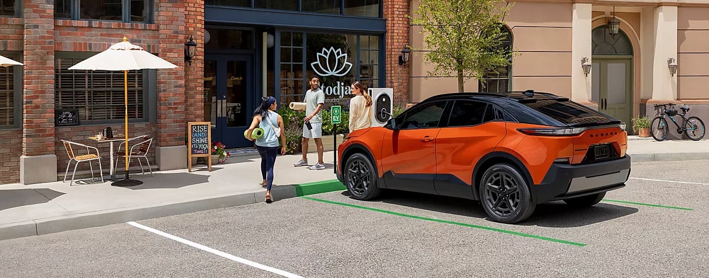 Orange 2026 Subaru Uncharted parked outside of a yoga studio