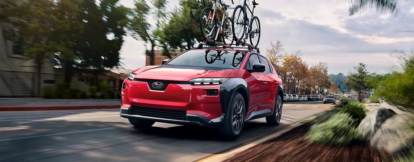 Red 2026 Subaru Solterra driving on a city street