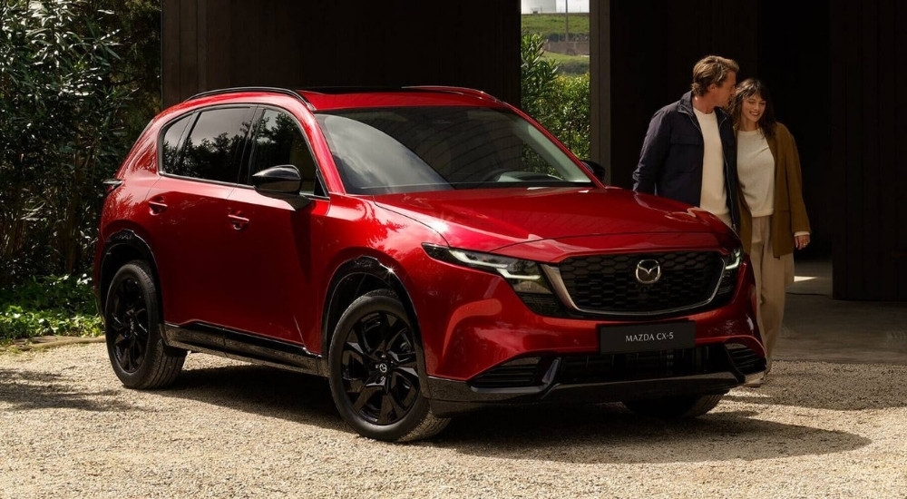 Couple walking near a red 2026 Mazda CX-5 for sale near Tomball