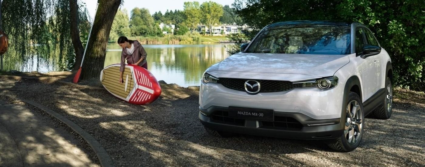 White 2023 Mazda MX-30 parked near a lake