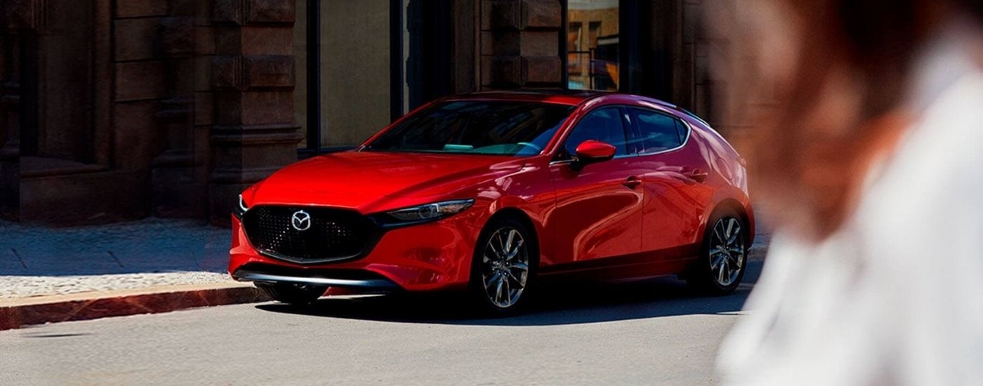Red 2019 Mazda3 parked in front of a building