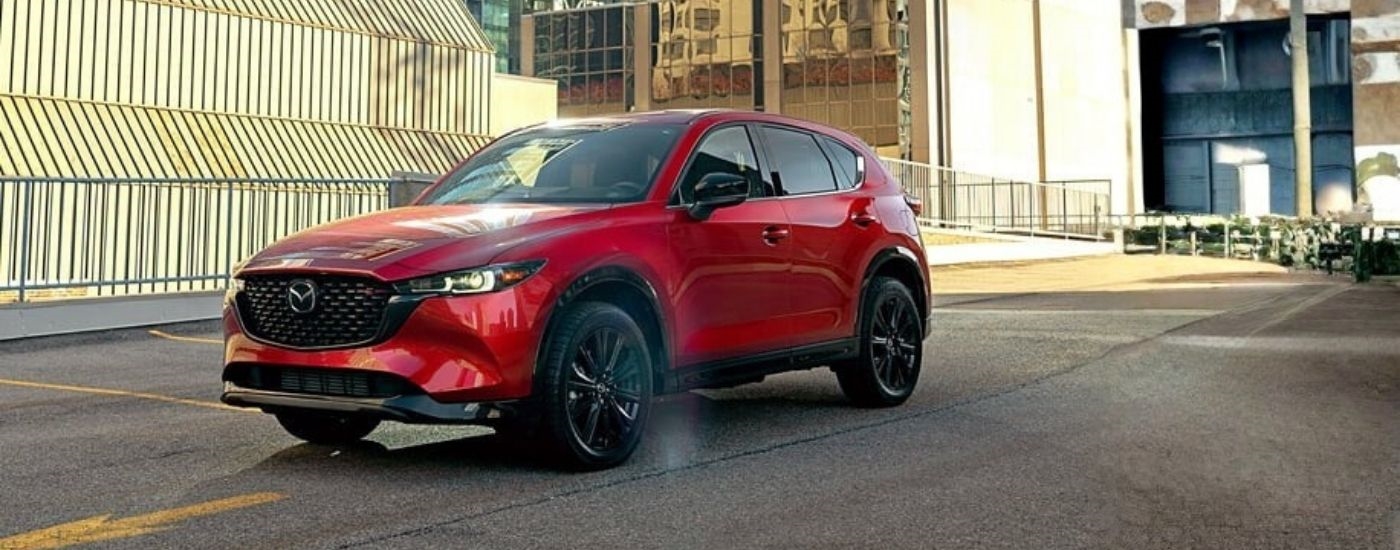 Red 2025 Mazda CX-5 for sale near Coral Terrace driving on a city street