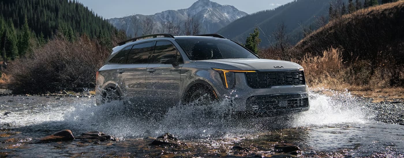 Grey 2026 Kia Sorento off-roading through a river