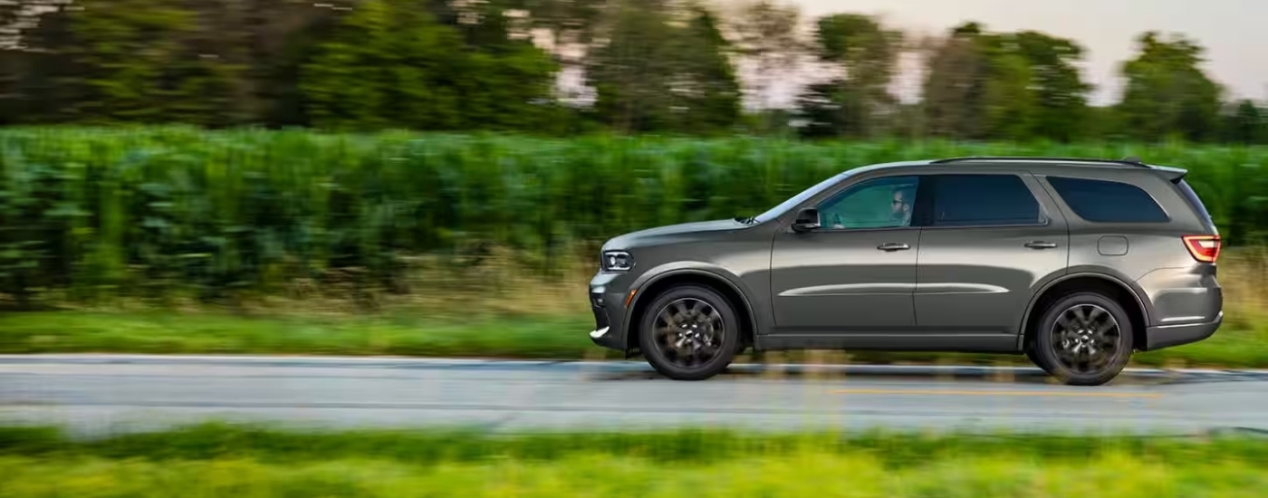 Grey 2025 Dodge Durango driving to a car dealership