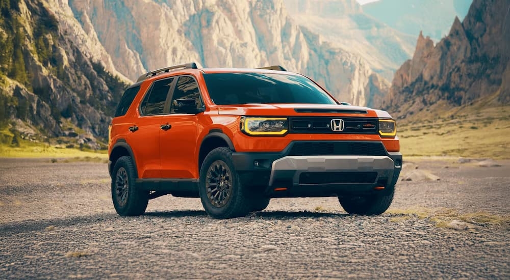 Orange 2026 Honda Passport TrailSport parked off-road.