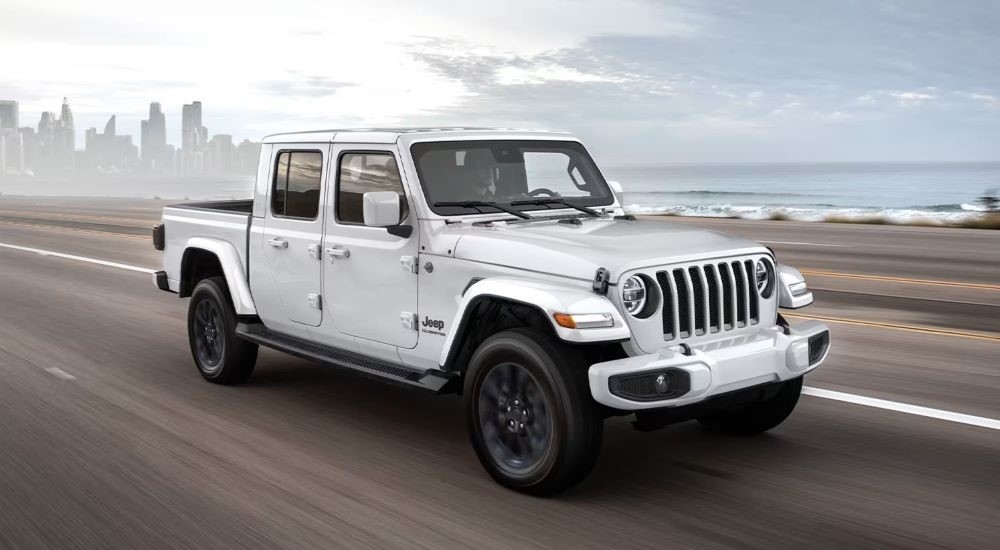 White 2020 Jeep Gladiator driving down a road.
