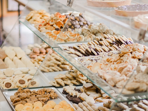 baked goods on display in a case at a bakery