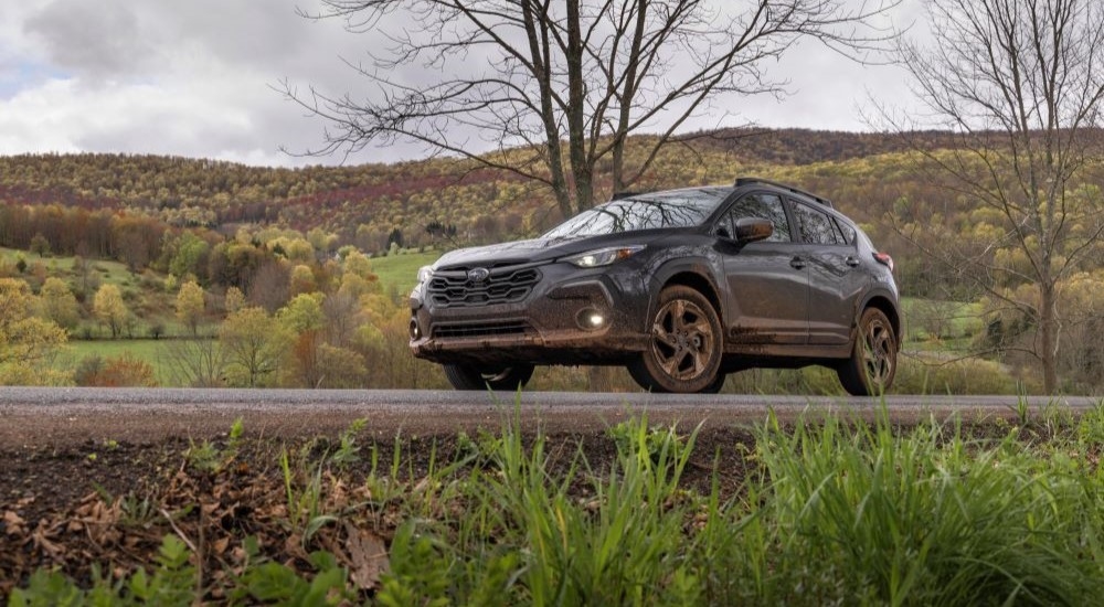 Grey 2026 Subaru Crosstrek Hybrid for sale in Rhinebeck driving down a road.