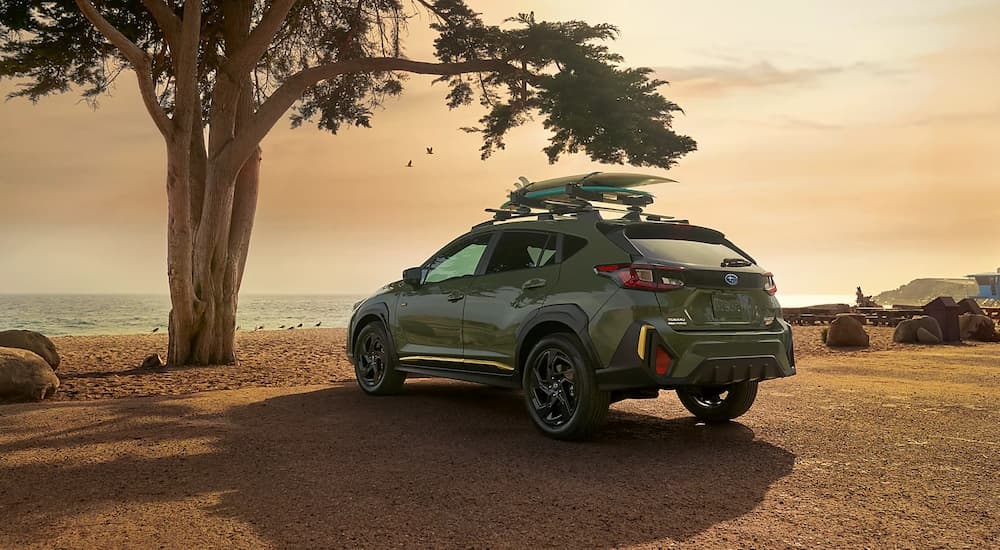 Rear of a green 2026 Subaru Crosstrek Hybrid parked off-road.