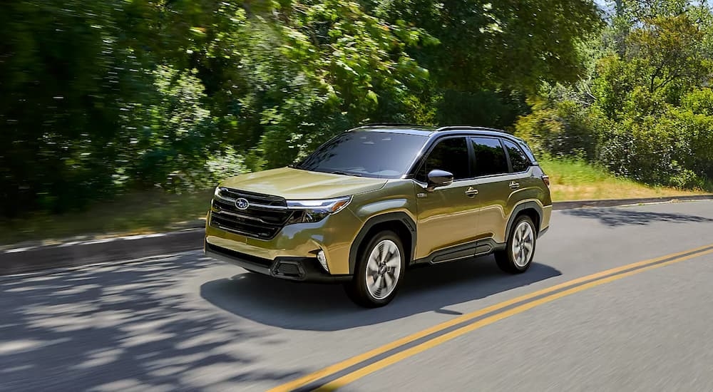Yellow 2026 Subaru Forester Hybrid driving down a road.