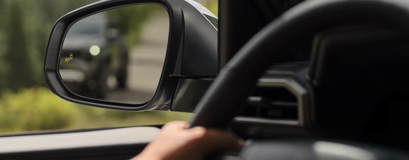 Steering wheel and side mirror on a 2025 Toyota Tacoma at a car dealership