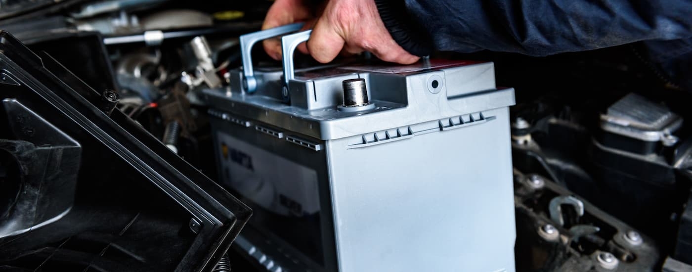 Mechanic installing a new battery into a car