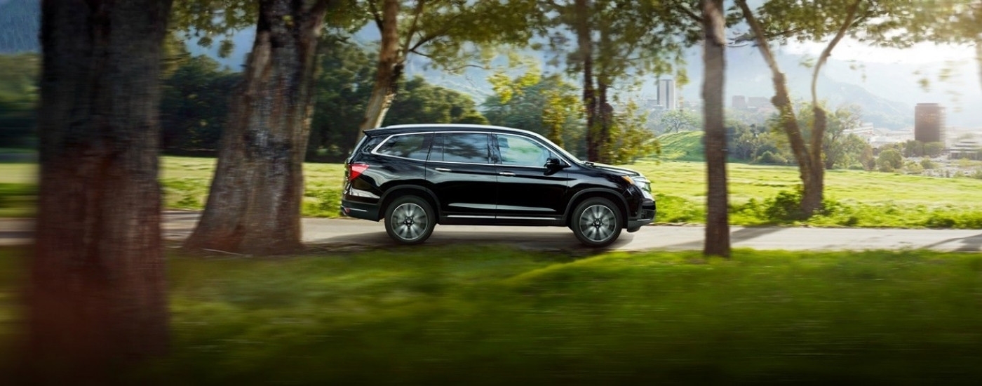 Black 2022 Honda Pilot driving to look at used SUVs for sale near Union City