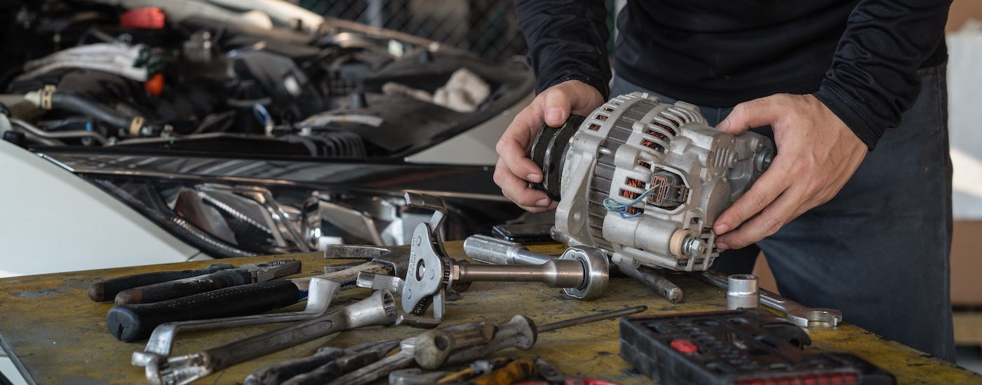 Person holding a car alternator.