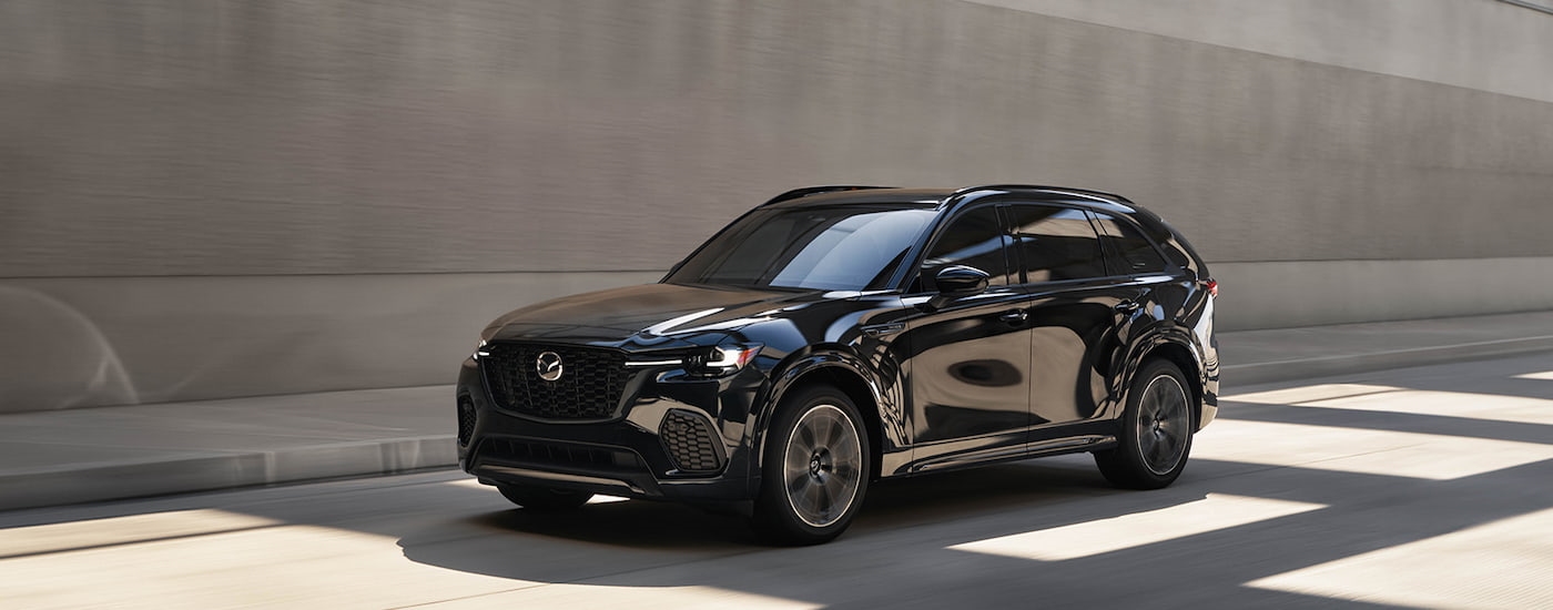 Side of a black 2025 Mazda CX-70 driving through a tunnel.