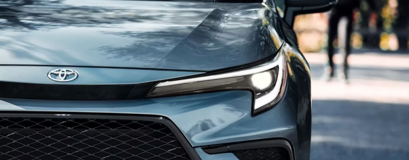 Headlight and grille on a blue 2023 Toyota Corolla XSE