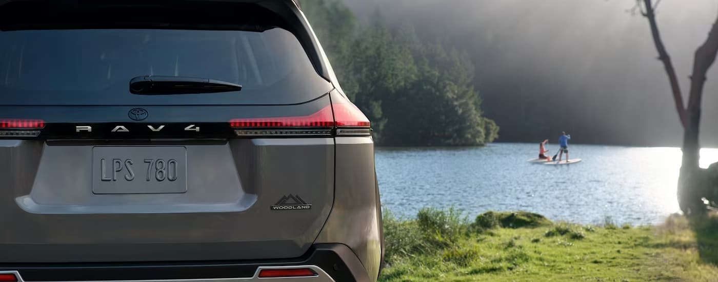 Rear of a grey 2026 Toyota RAV4 Woodland by a lake