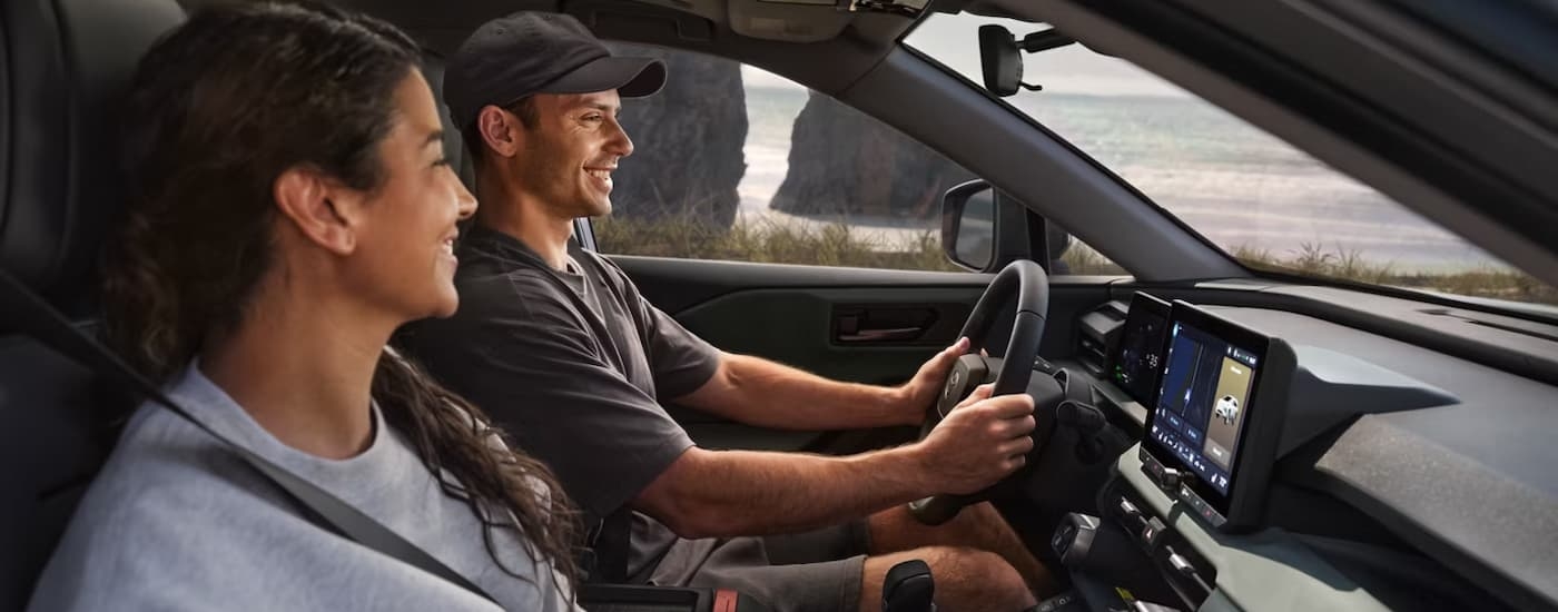 Two people driving in a 2026 Toyota RAV4