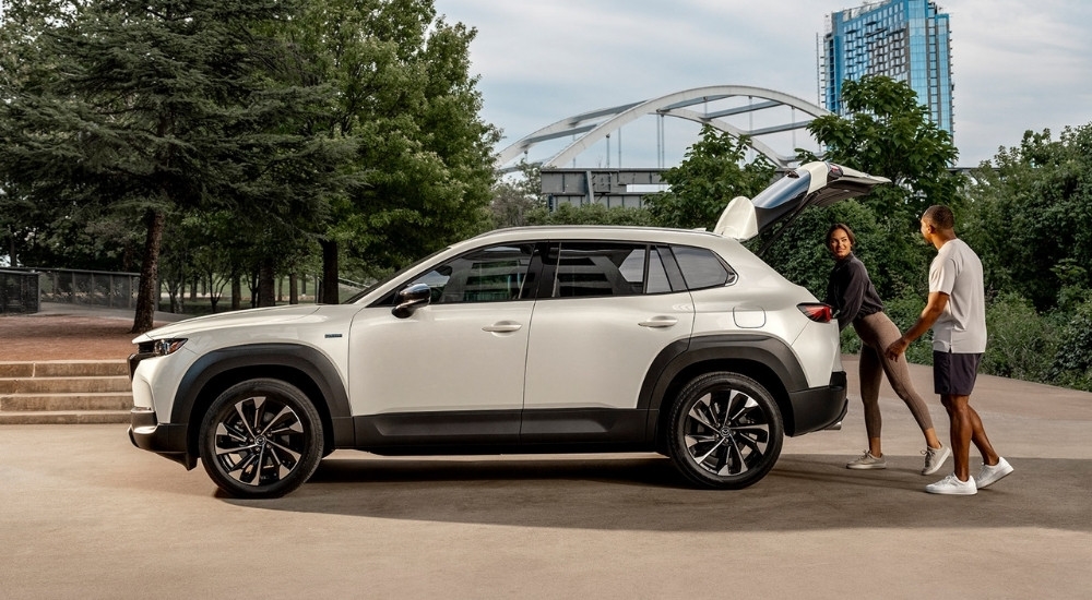 Couple near a white 2025 Mazda CX-50 Hybrid