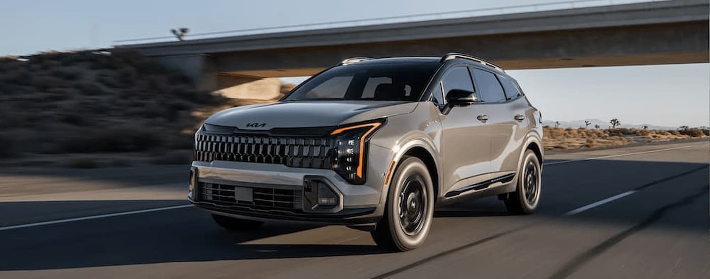 A gray 2026 Kia Sportage driving on a highway