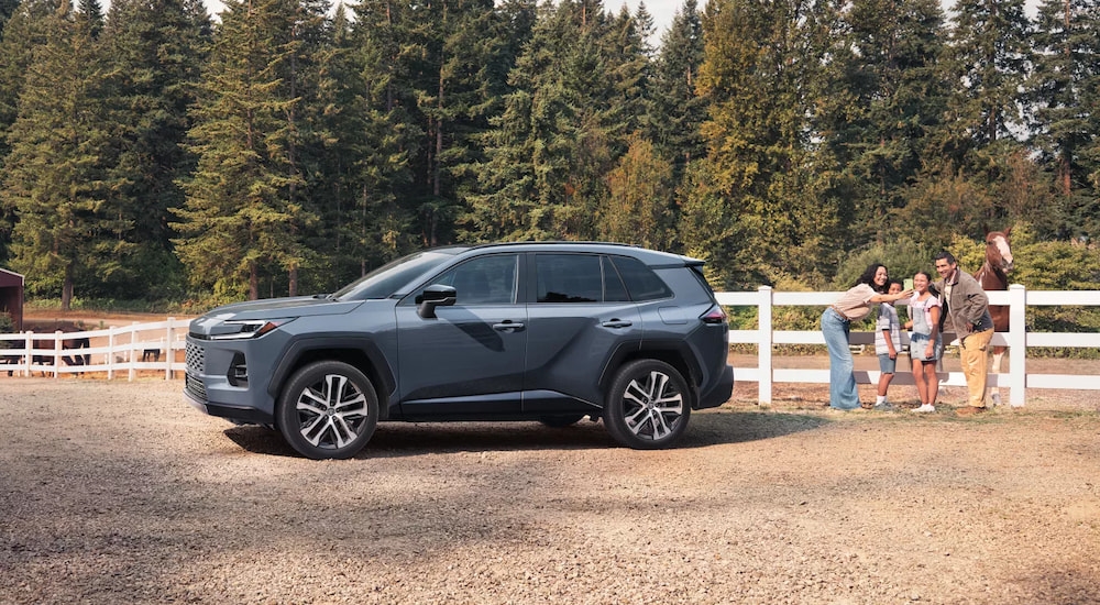 Grey 2026 Toyota RAV4 for sale near Glasgow parked by a white fence.