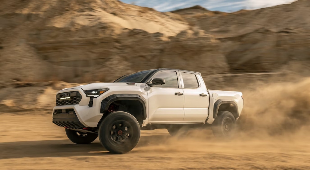 White 2026 Toyota Tacoma driving off-road.