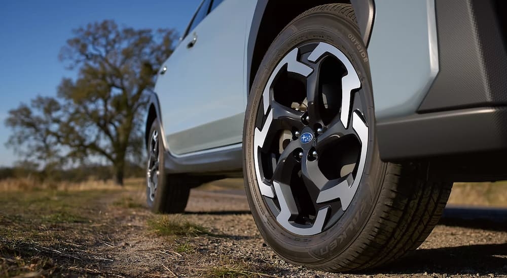 Rim and tire on a light blue 2024 Subaru Crosstrek near a used car dealership