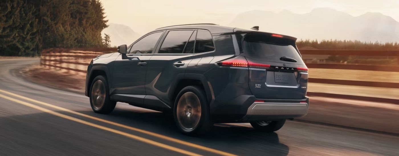 Blue 2026 Toyota RAV4 driving on a winding road