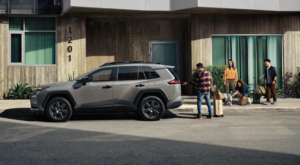 Group of people loading luggage into a grey 2026 Toyota RAV4