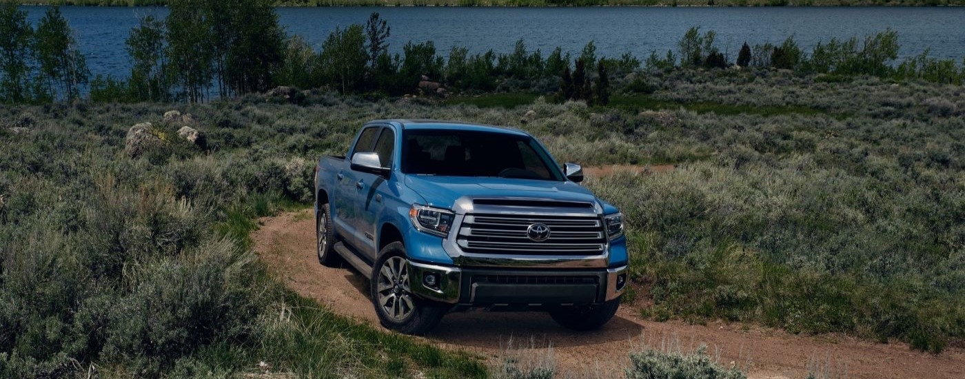 Blue 2020 Toyota Tundra driving down a dirt road.