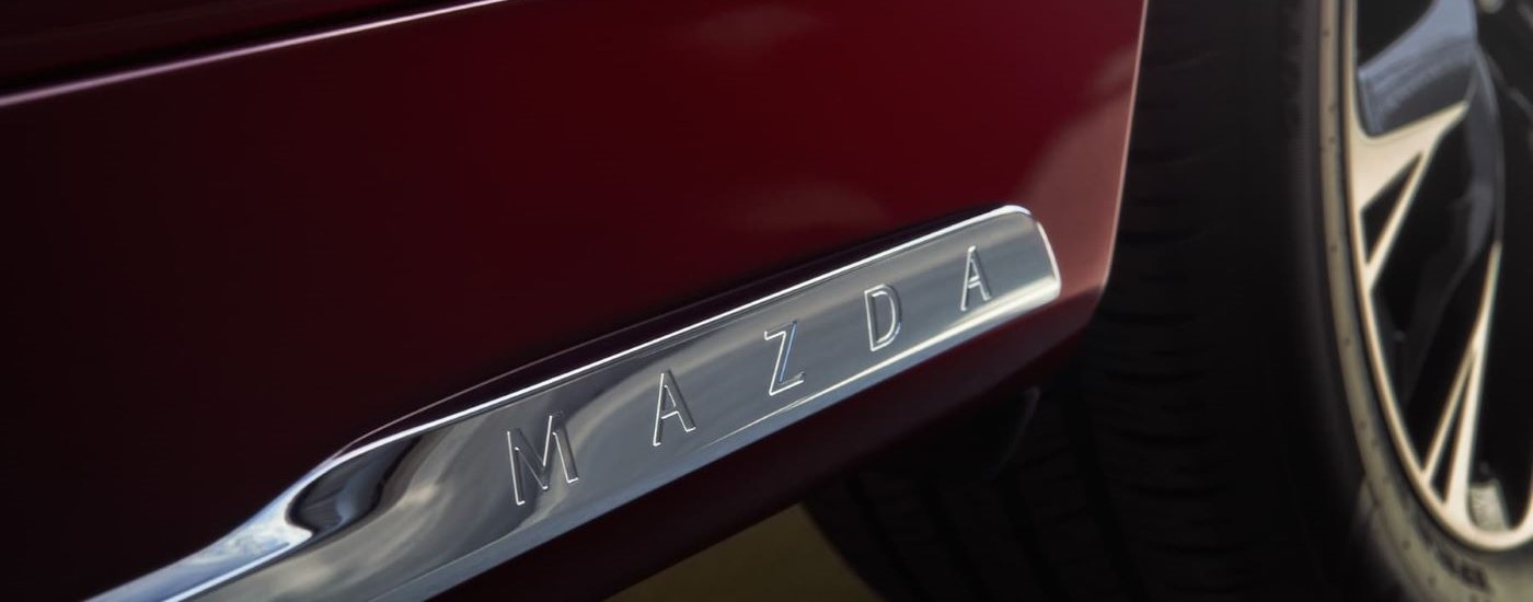 Mazda badging on a red 2025 Mazda CX-90 Hybrid for sale near Coral Gables