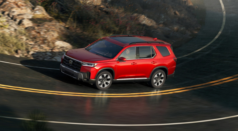 Red 2026 Honda Pilot rounds a bend