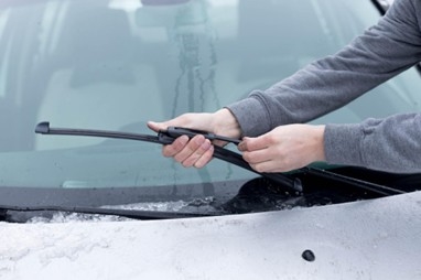 Technician replacing windshield wiper blades