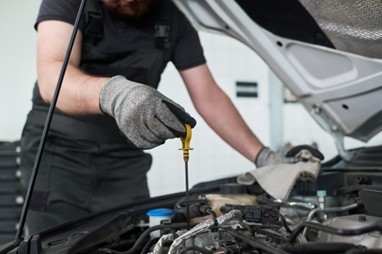 Checking engine oil level during spring maintenance