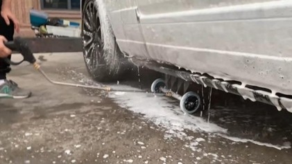 Vehicle receiving professional undercarriage wash to remove winter salt in Kenosha WI