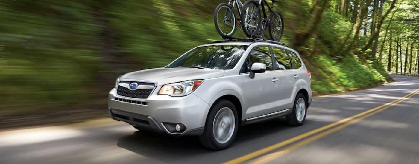 White 2016 Subaru Forester driving down a road.