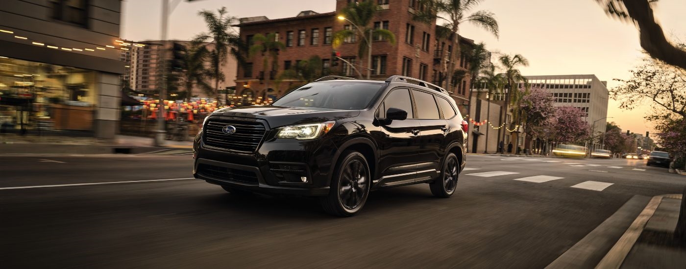 Black 2022 Subaru Ascent Onyx Edition driving down a city street.