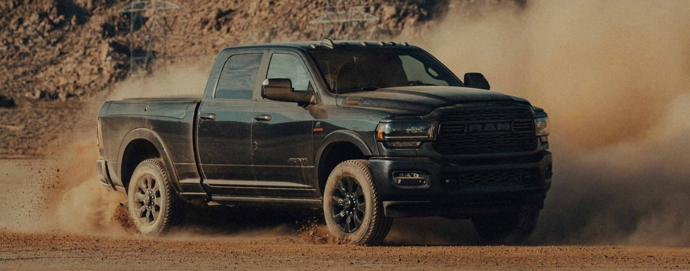 Black 2022 Ram 2500 drifting on a dusty lot