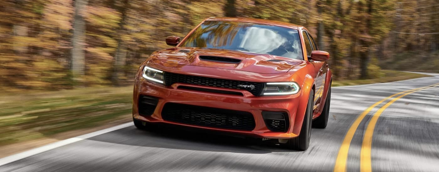Orange 2022 Dodge Charger SRT driving on a back road