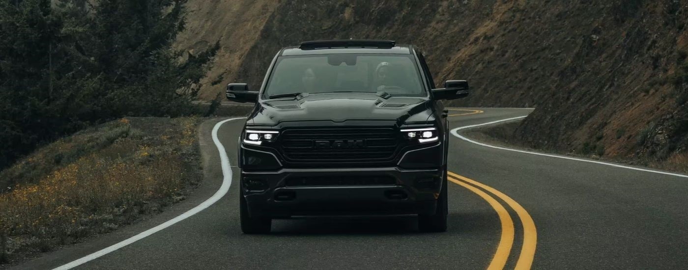 Black 2023 Ram 1500 driving up a winding road