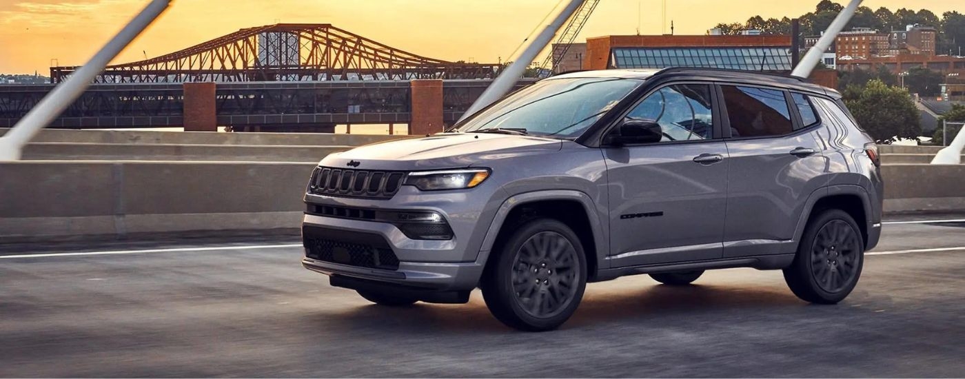 Silver 2022 Jeep Cherokee driving over a bridge