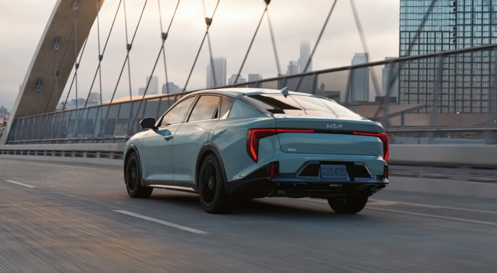 Grey 2026 Kia K4 driving over a bridge