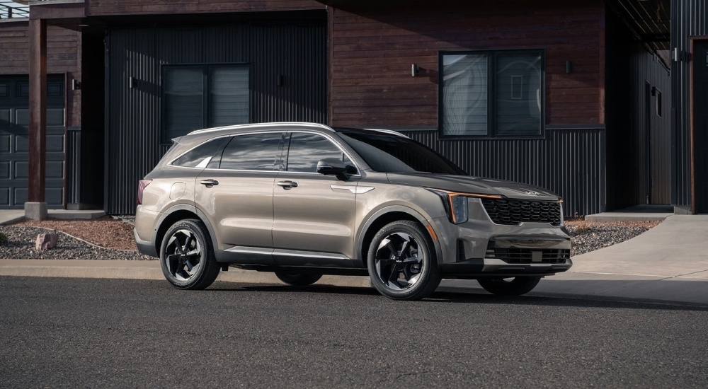 Side of a grey 2026 Kia Sorento parked on pavement.