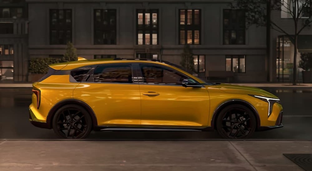 A yellow 2026 Kia K4 Hatch parked in a city.