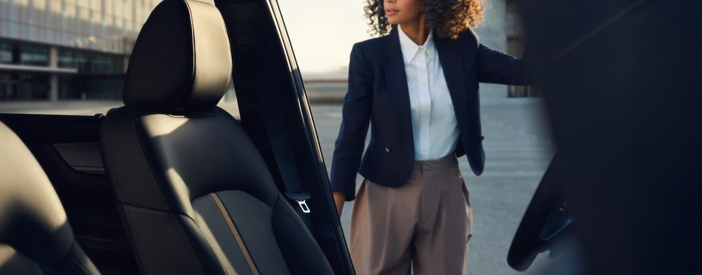 Woman opening the driver's door of a 2026 Mazda CX-90