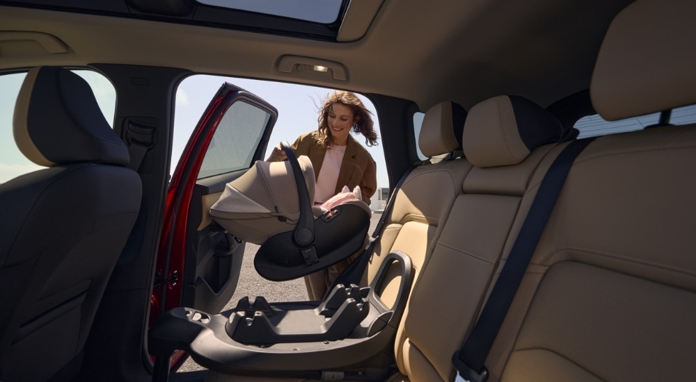 Person putting a carseat into a 2026 Mazda CX-5